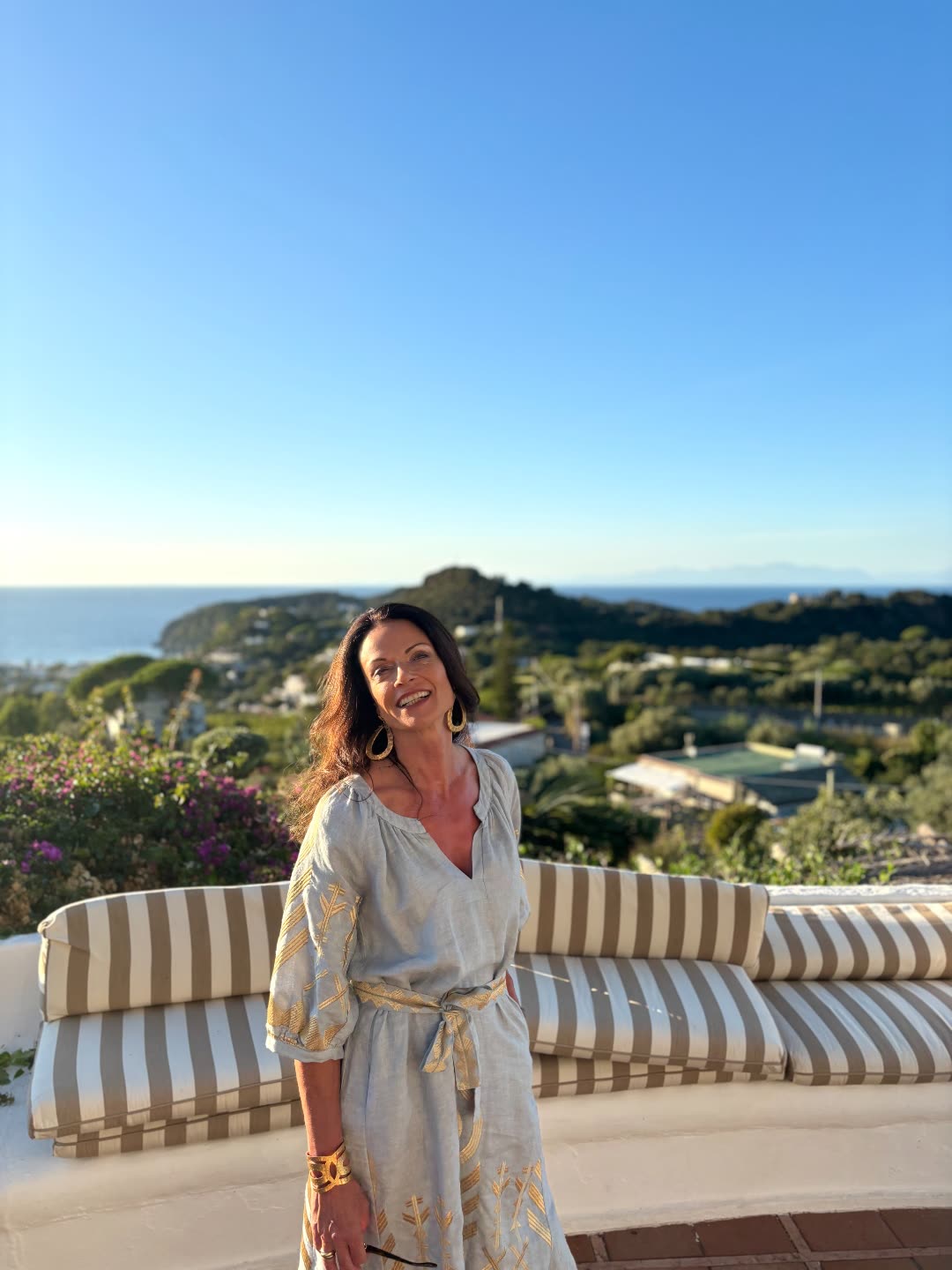 Marina im Leinenkleid auf einer Terrasse mit Meerblick — Lifestyle, der trägt
